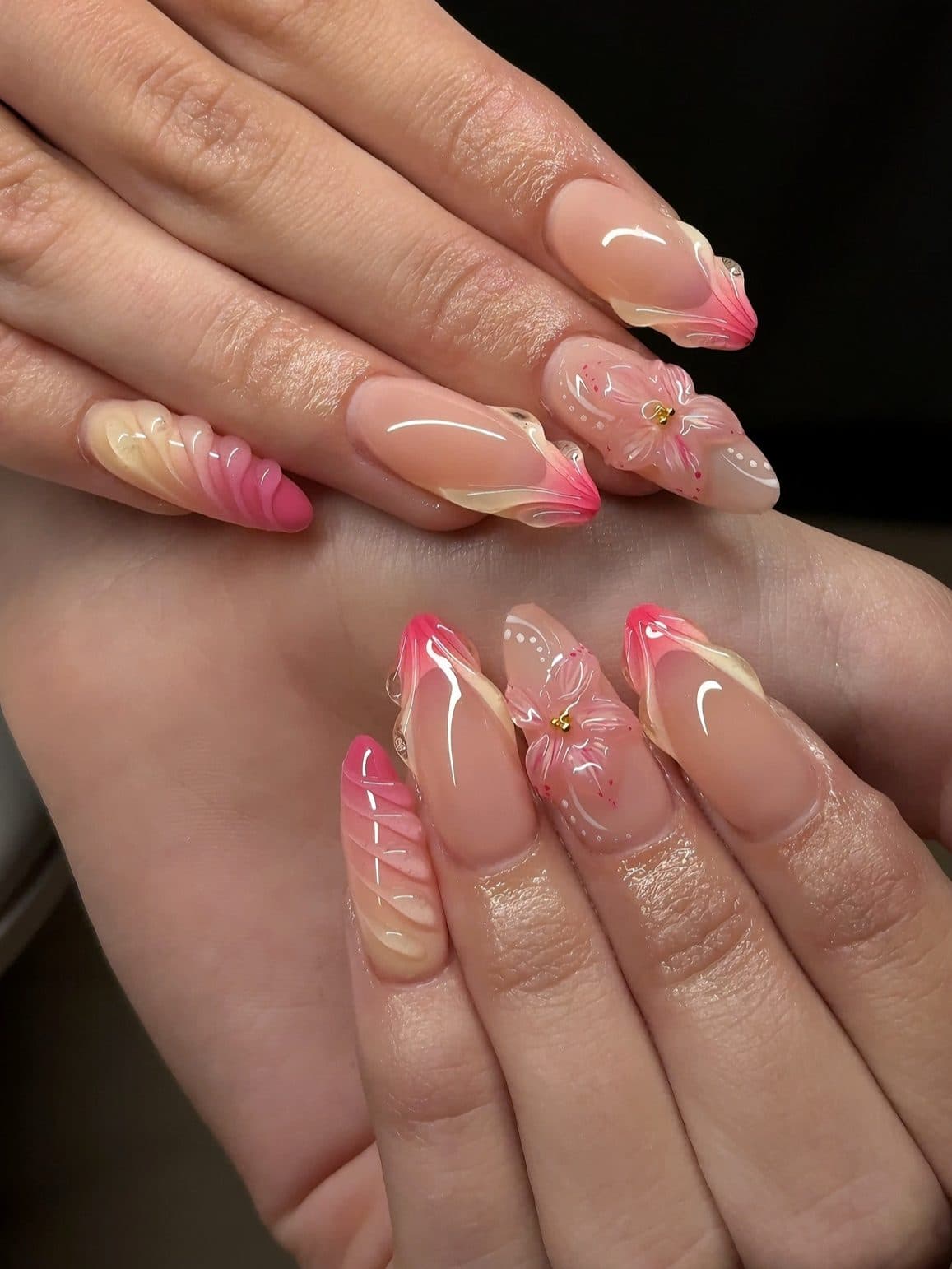 Almond Gel-X nails with pink and peach swirls, 3D pink flowers and gold pearls
