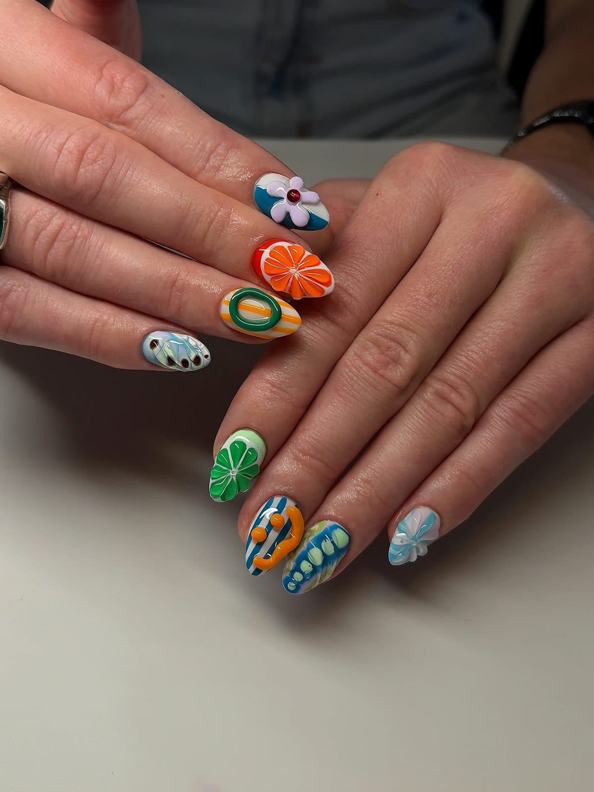Fruity almond Gel-X set with painted orange slices, kiwi, a flower and polka dots